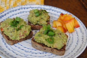 open face rye bread avocado sandwich and diced peaches