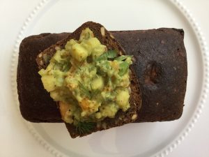 avocado topped slice of bread on top of the loaf